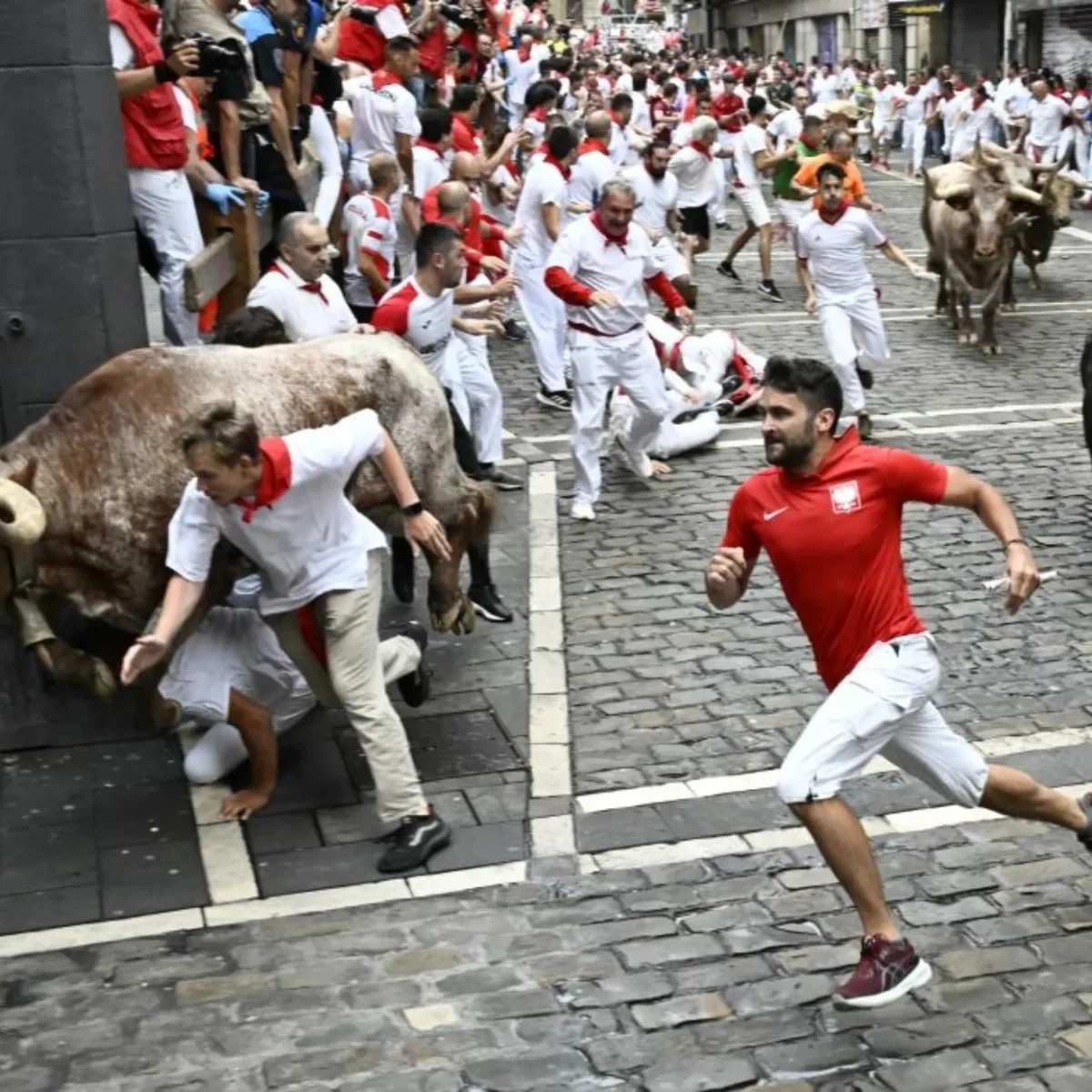 Corredores con pañuelo rojo en el encierro de los Sanfermines en Pamplona